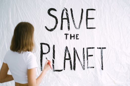 Back view of woman painting 'Save the Planet' message on wall, promoting environmental awareness.